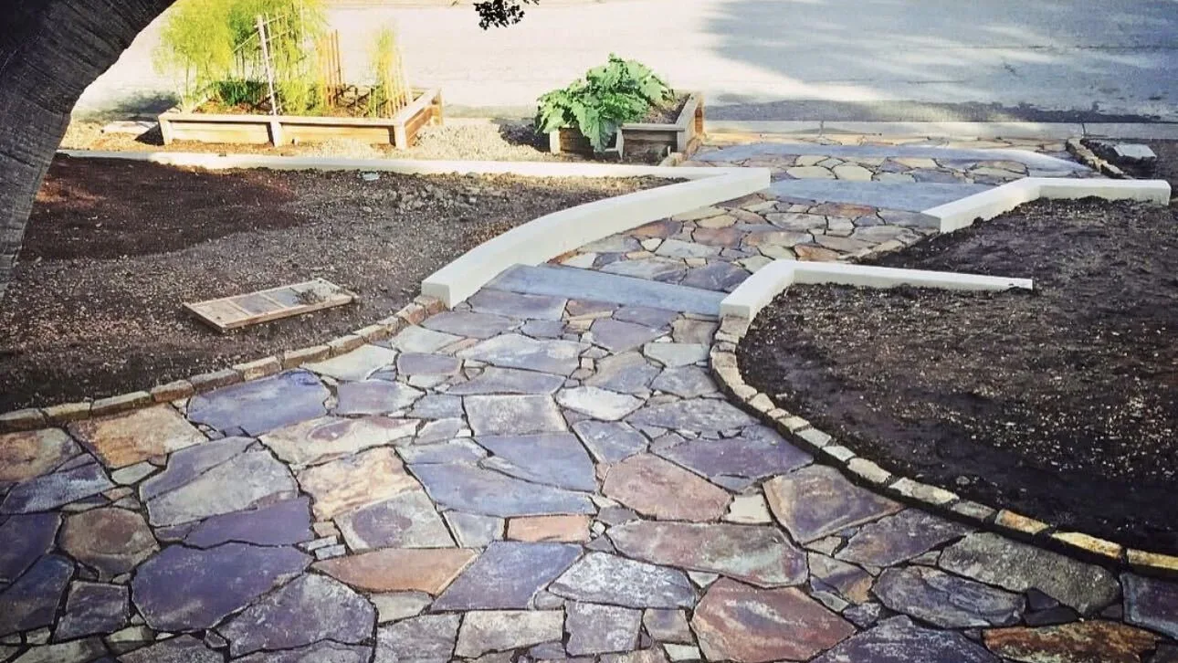 Flagstone front walk with white concrete curbs and a stone border by Aguilar and Sons Construction, serving Capitola, CA