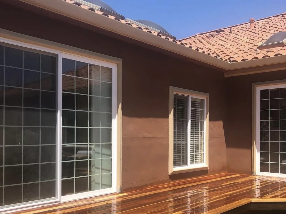 Freshly finished redwood deck along sliding glass doors and a tile roof